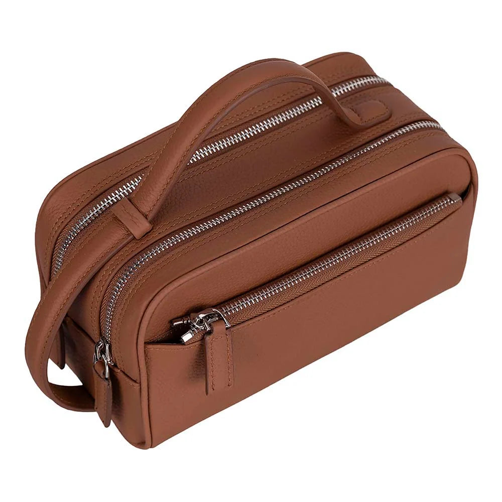 A brown pebbled leather toiletry bag with a top handle, multiple zippered compartments, and a detachable shoulder strap, shown on a solid white background.