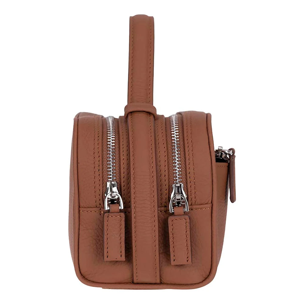 A brown faux-leather crossbody bag with a top handle, featuring two front zippered pockets with silver-tone metal zippers and pull tabs, shown against a plain white background.