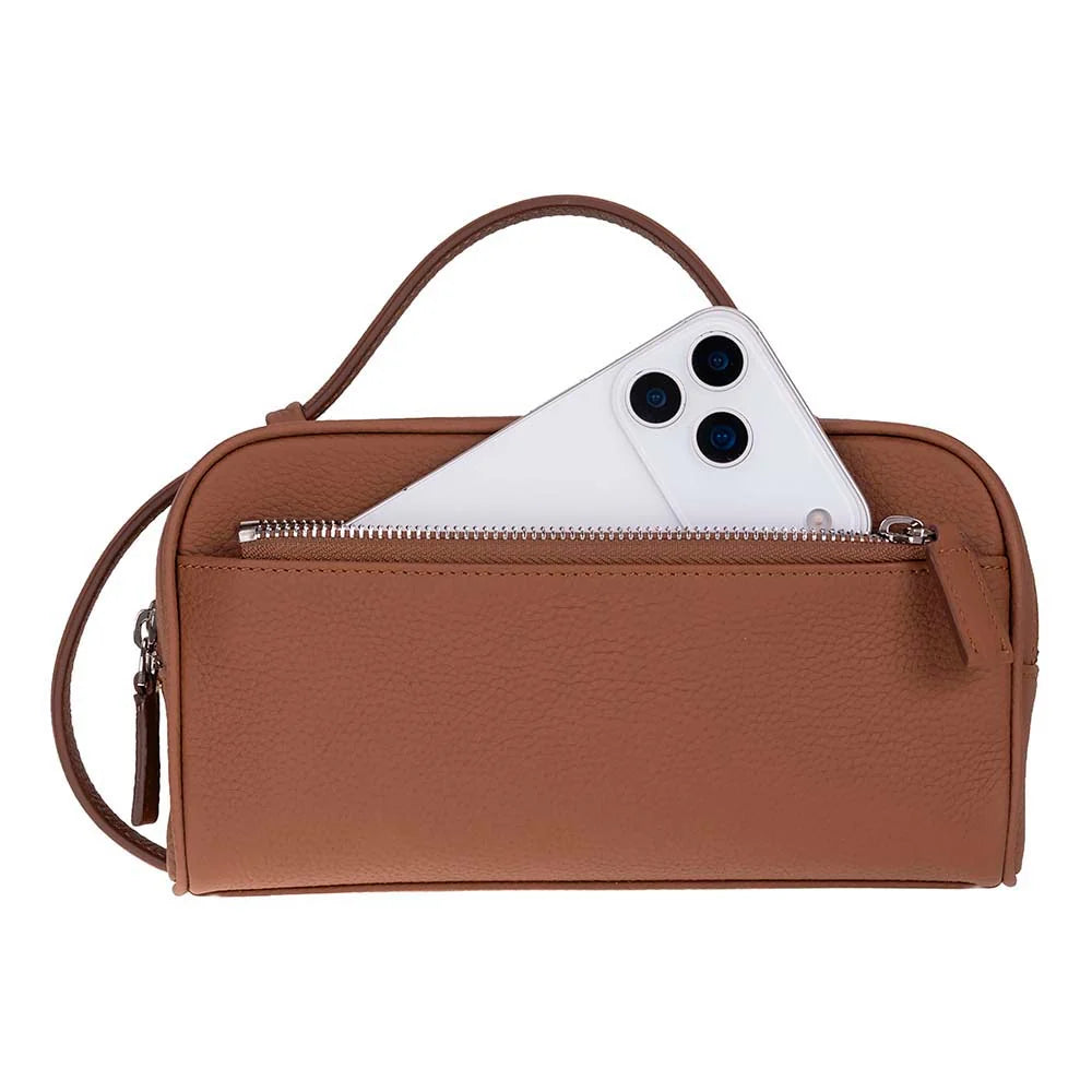 A brown pebbled leather crossbody bag with a top handle and a zippered front pocket, shown with a white smartphone partially tucked into the pocket against a plain white background.