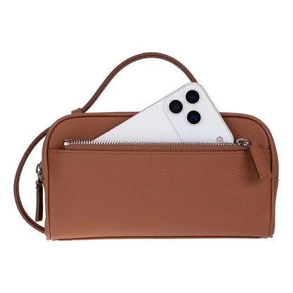 A brown pebbled leather crossbody bag with a top handle and a zippered front pocket, shown with a white smartphone partially tucked into the pocket against a plain white background.